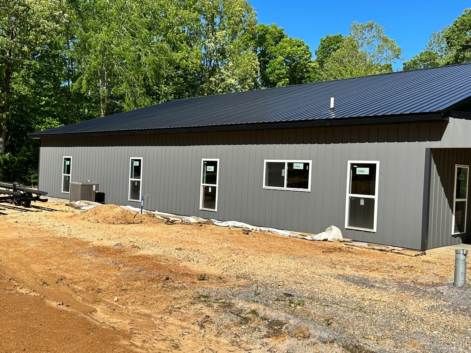 Finished metal building exterior using gray metal panels and black roofing